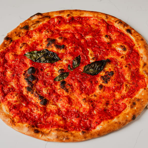 Pazza Pizza's classic Margherita pizza with vibrant red sauce, fresh basil leaves, and a perfectly charred crust.
